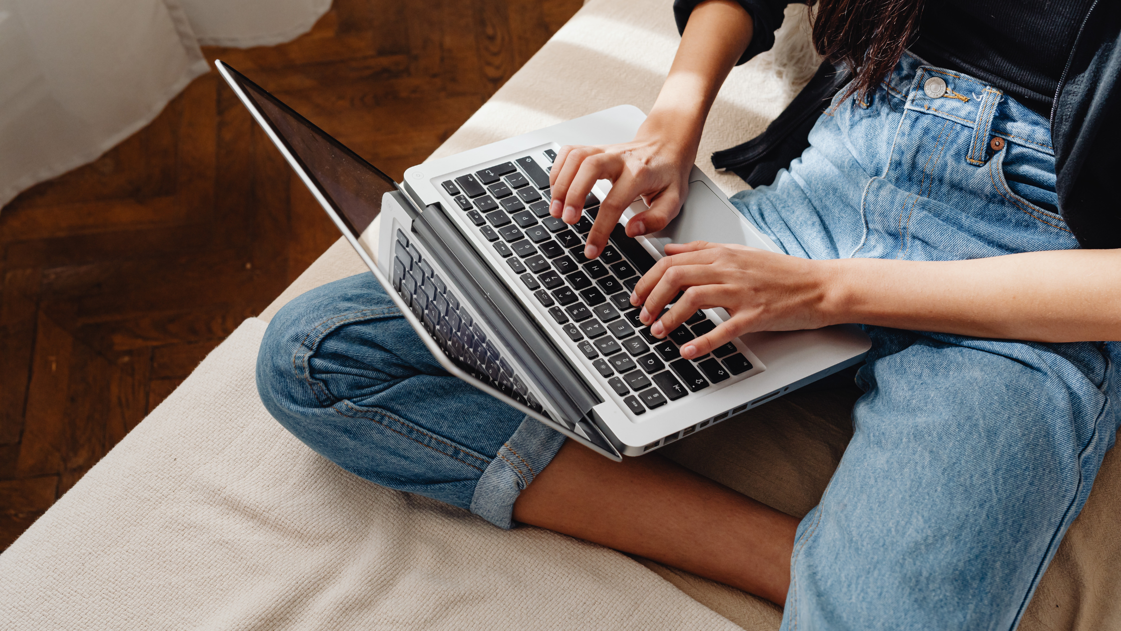 casual woman in jeans writing the optional essay on a laptop