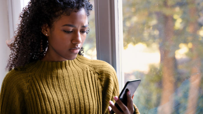 A woman checking her phone for med school interview invitations